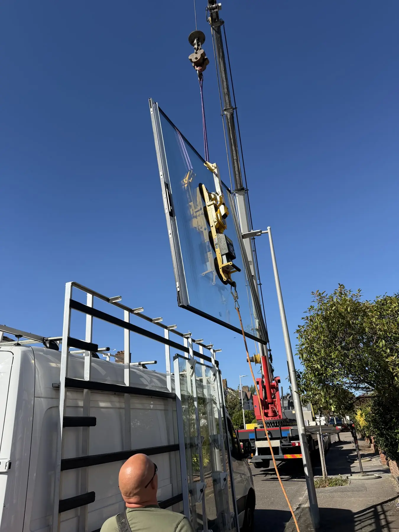 A large glass panel being craned into place