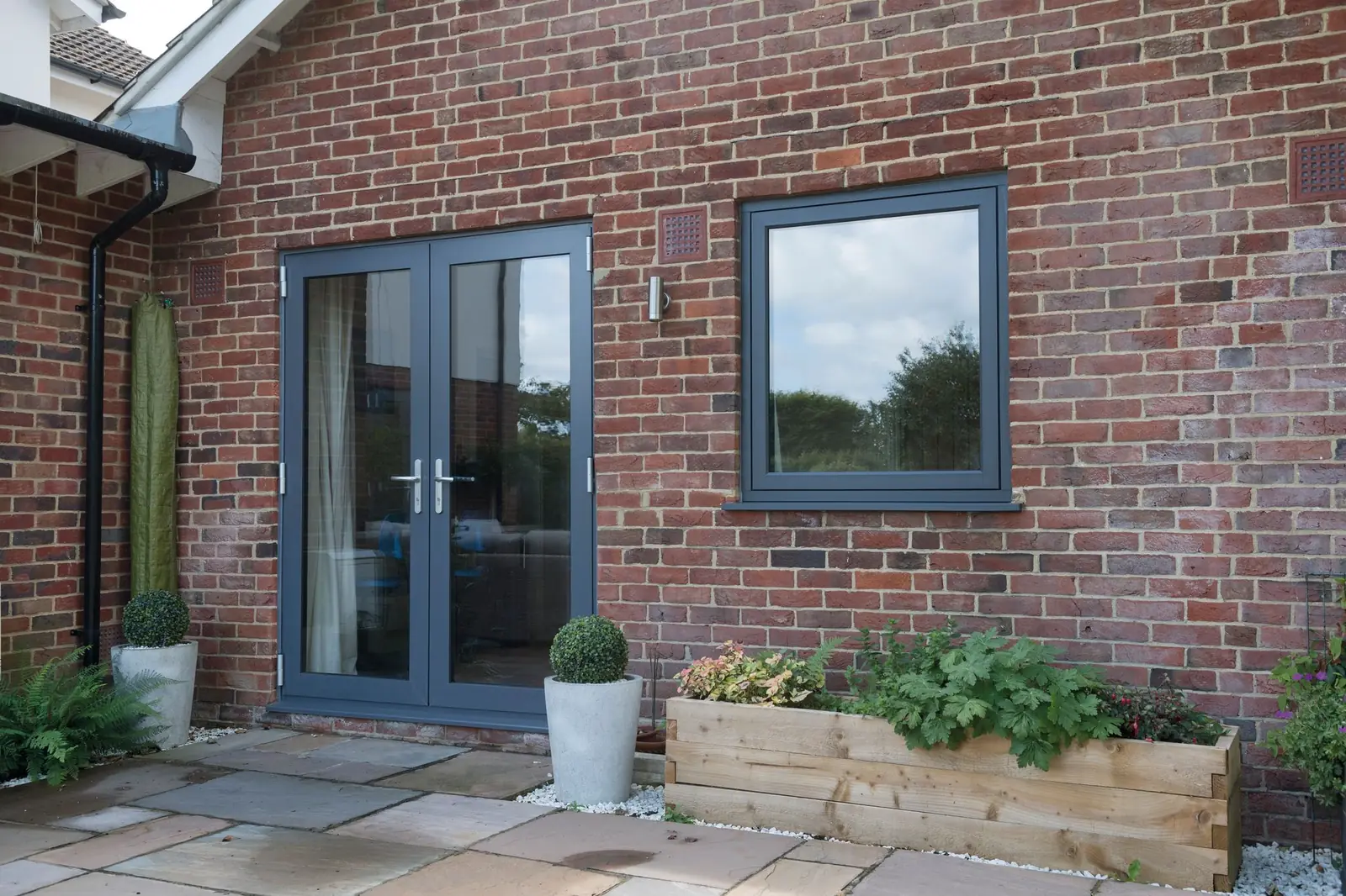 Grey French doors opening onto a patio