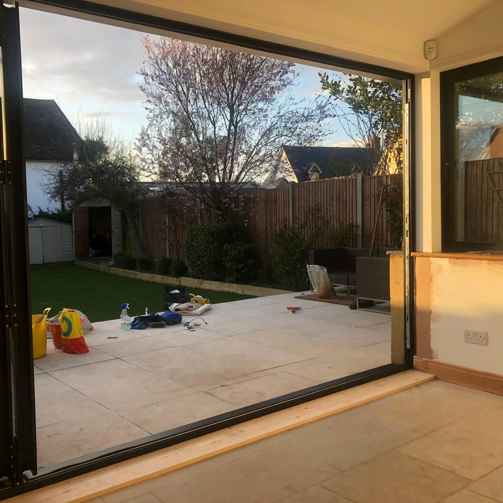 Black aluminium bifold doors folded open to the garden