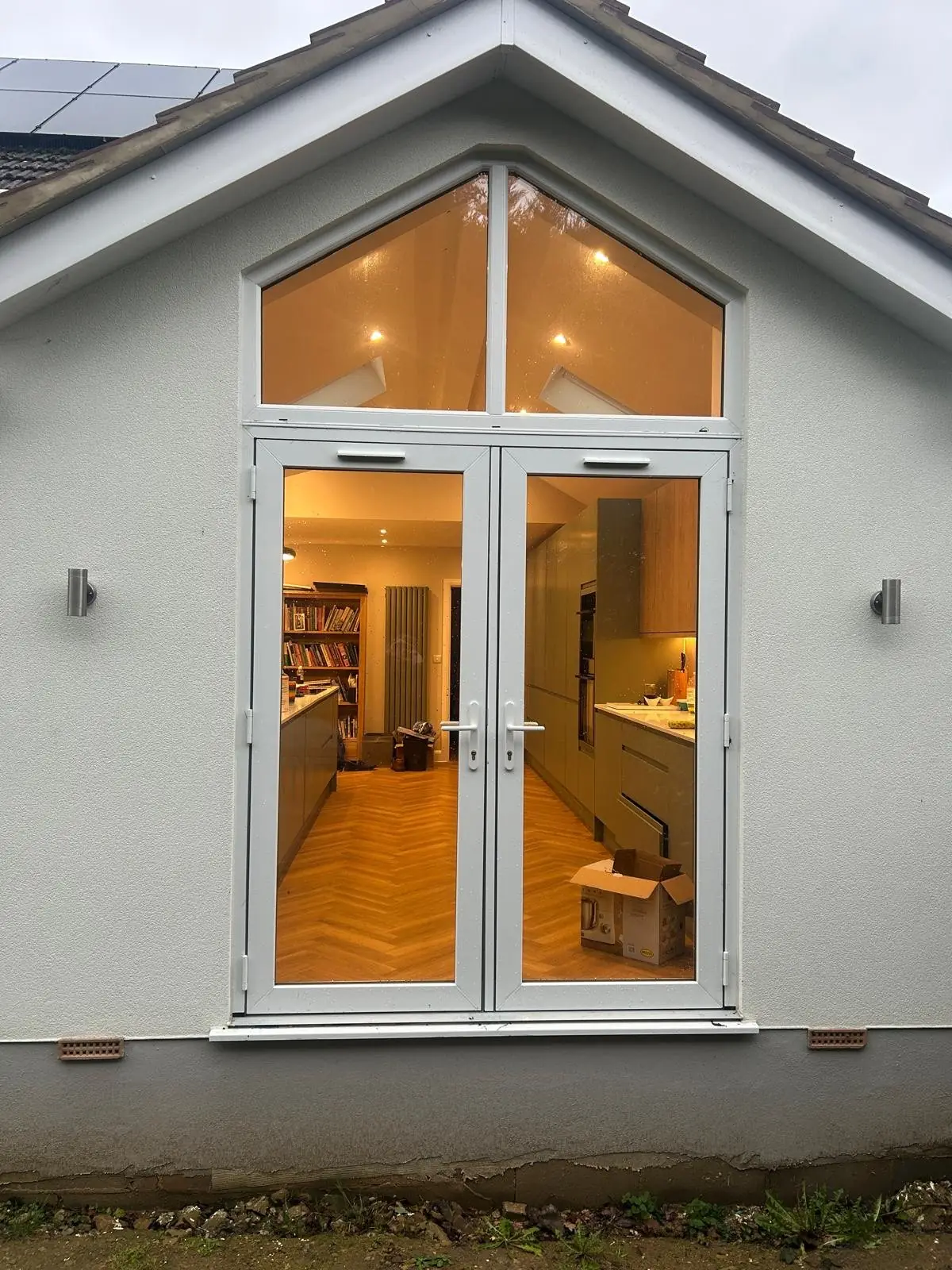 White French doors and gable glazing, lit from inside